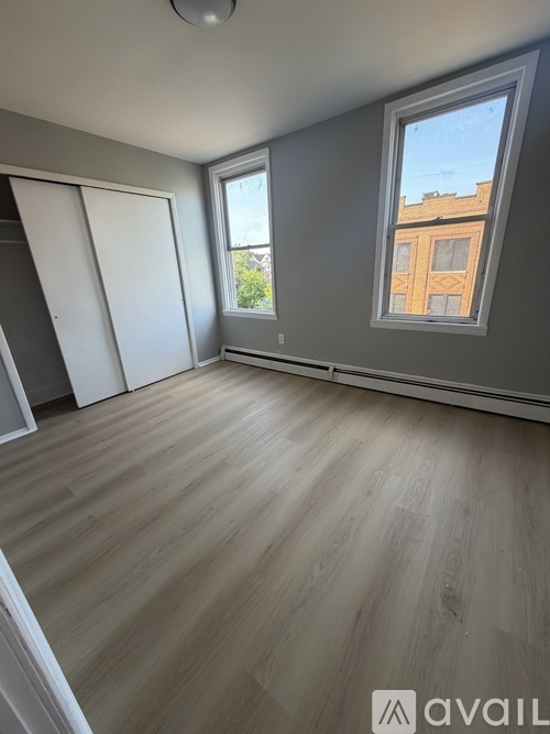 A room with a slanted ceiling and a window showing a building outside.