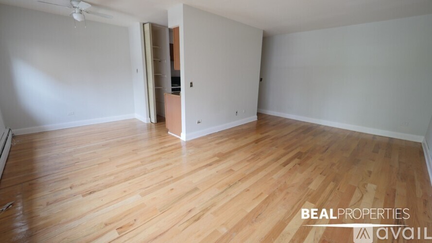 A room with wooden flooring and a ceiling fan.
