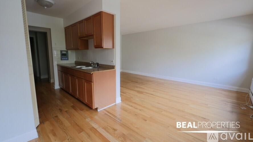 A kitchen area with wooden floors and white walls.
