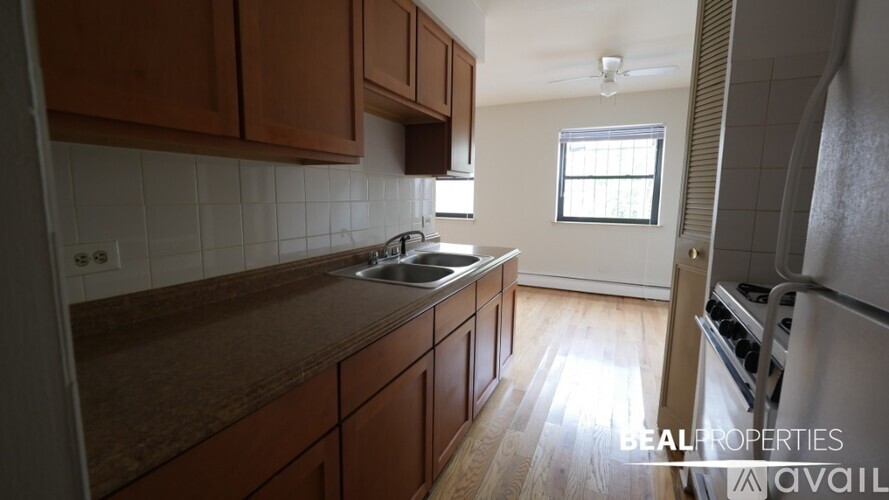 A kitchen with brown cabinets and a window.
