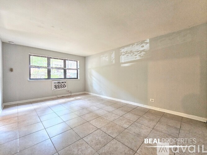 A room with a tiled floor and a window with blinds.