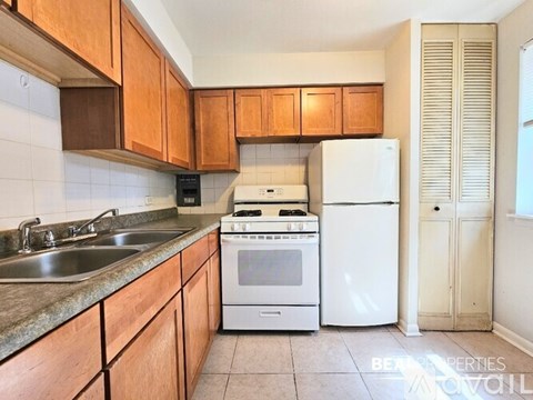 A kitchen with wooden cabinets and a white fridge.