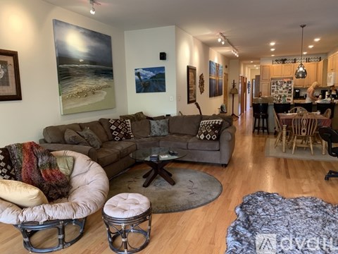 A living room with a couch, chair, and a painting on the wall.
