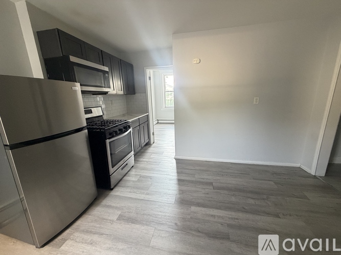 A kitchen with a refrigerator, oven, and microwave.