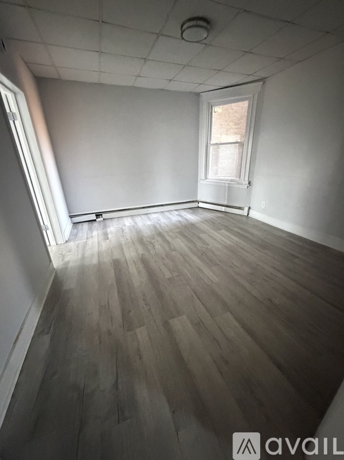 A room with wooden flooring and a window.