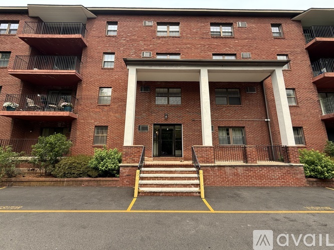 A red brick building with a white entrance and steps leading up to it.