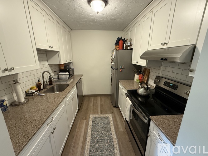 A kitchen with white cabinets and a black stove top oven.