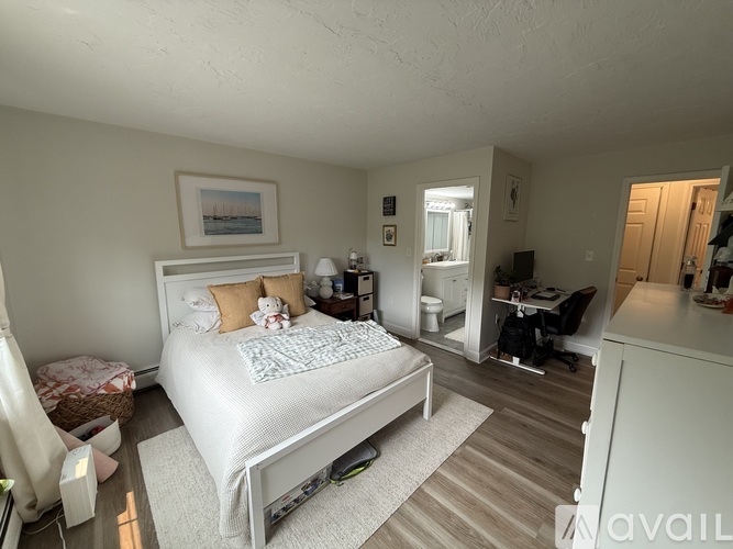 A bedroom with a large bed and a desk with a chair.