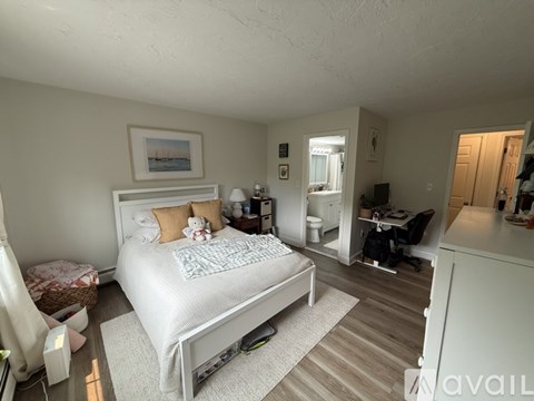 A bedroom with a large bed and a desk with a chair.