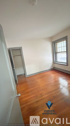 A room with wooden floors and a window is available for rent.