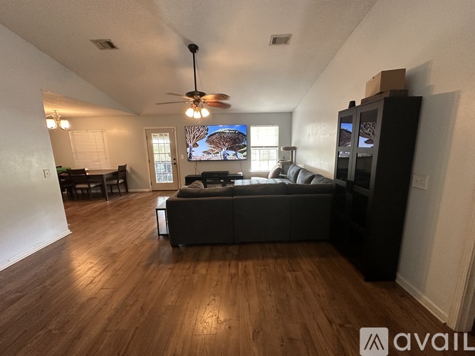 A living room with a dark grey couch and a wooden floor.