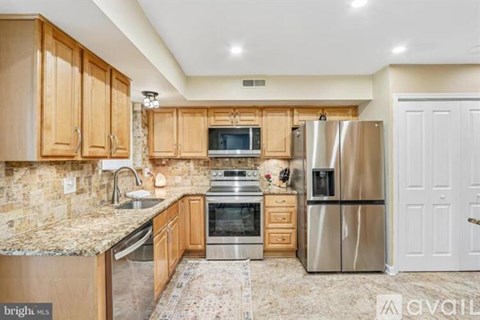 A kitchen with wooden cabinets and granite countertops.