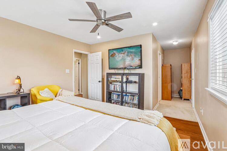 A bedroom with a large bed and a ceiling fan.