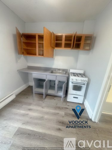 A kitchen area with a white dishwasher and a white table with a white cabinet above it.