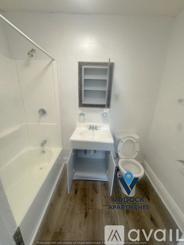 A small bathroom with a toilet, sink and bathtub.