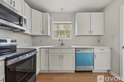 A kitchen with white cabinets and a blue dishwasher.