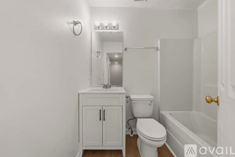 A white bathroom with a toilet, sink, and bathtub.
