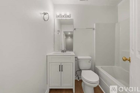 A white bathroom with a toilet, sink, and bathtub.