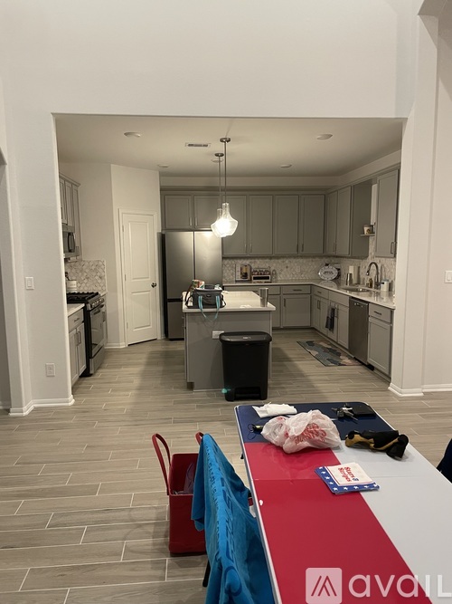 A kitchen with a red table and a blue chair.