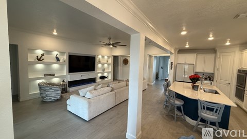 A spacious living room with a white sofa and a television.