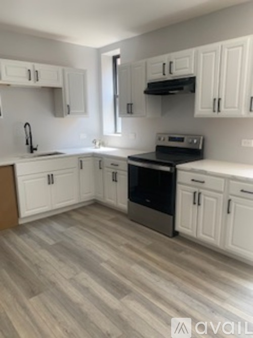 A kitchen with white cabinets and a black stove top oven.