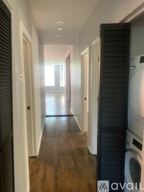 A long hallway with a washer and dryer on the right.