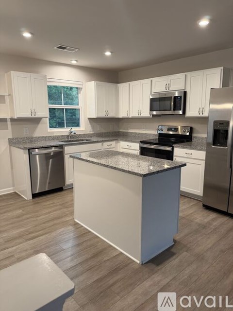 A kitchen with a granite countertop and stainless steel appliances.
