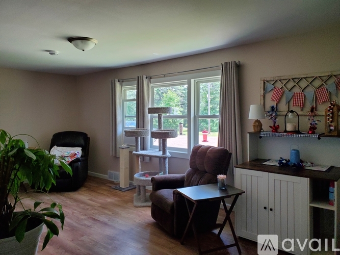 A living room with a brown leather chair, a small table, and a potted plant.