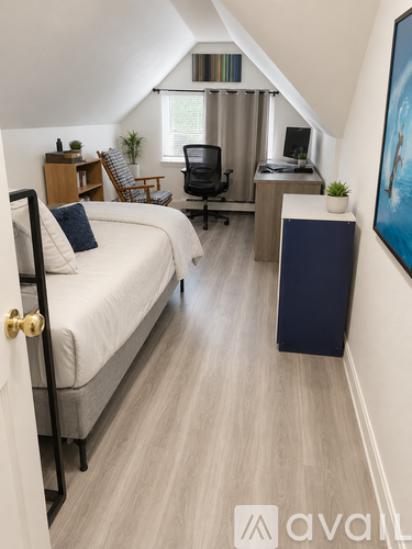 A bedroom with a bed, desk, and chair.