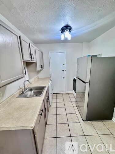 A kitchen with white cabinets and a sink.