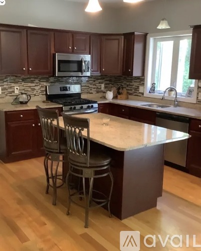 A kitchen with brown cabinets and a white island.