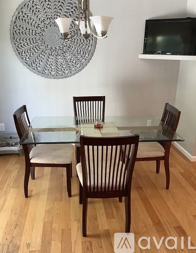 A dining room with a glass table and chairs.