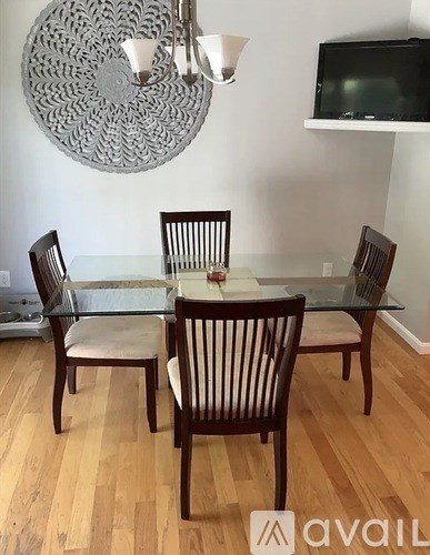 A dining room with a glass table and chairs.