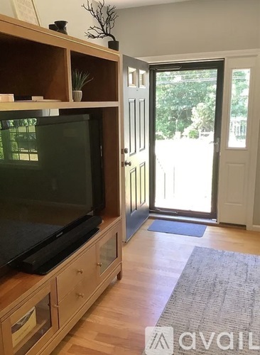 A living room with a television and sliding glass doors.