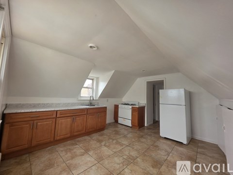 A kitchen with a white fridge and brown cabinets.