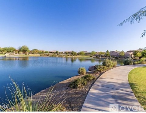 A serene lake surrounded by a residential area with houses and greenery.
