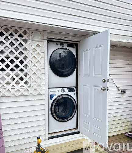 A washing machine and dryer are installed in a small outdoor space.
