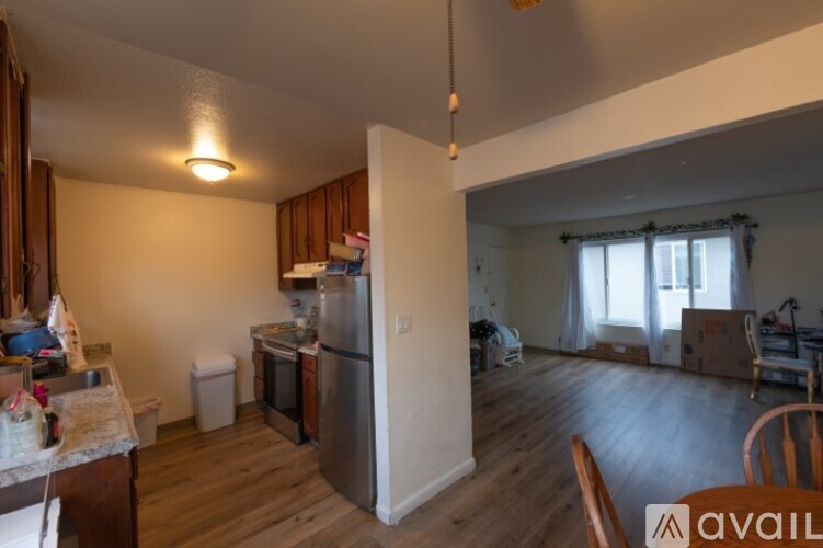 A kitchen with wooden floors and a refrigerator.