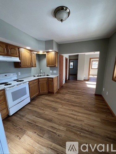 A kitchen with wooden floors and white appliances.