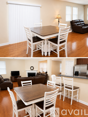 A living room with a brown couch and a white dining table.
