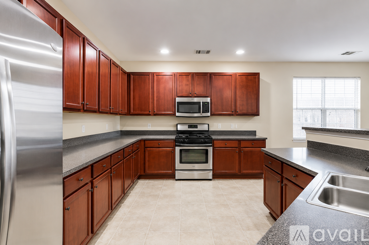 A kitchen with brown cabinets and a stainless steel refrigerator.