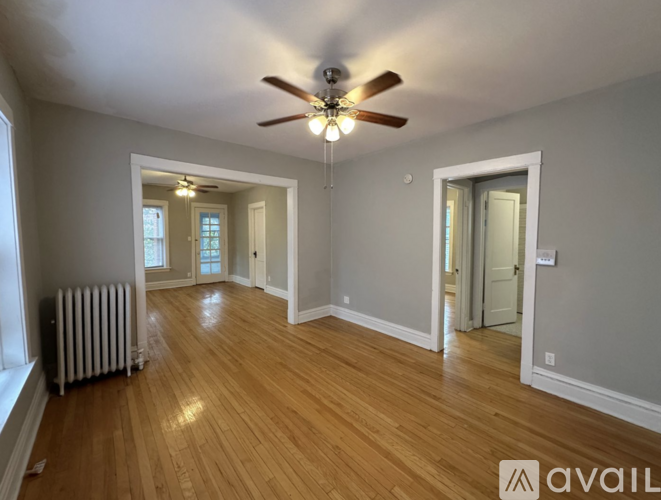 A room with wooden floors and a ceiling fan.