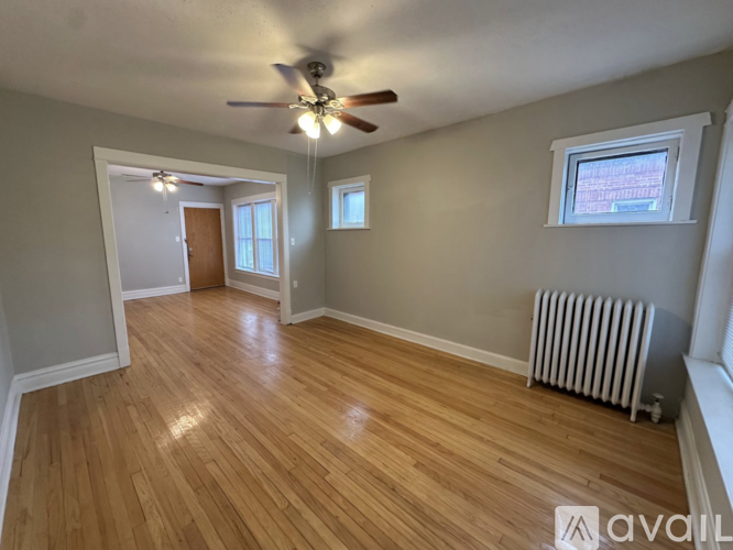 A room with wooden flooring and a ceiling fan.