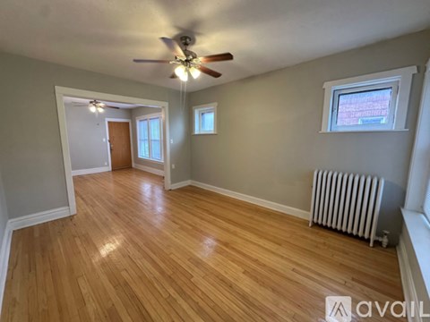 A room with wooden flooring and a ceiling fan.