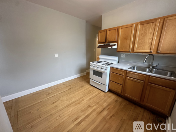 A kitchen with wooden cabinets and a white stove top oven.
