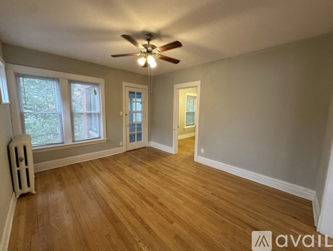 A room with wooden flooring and a ceiling fan.
