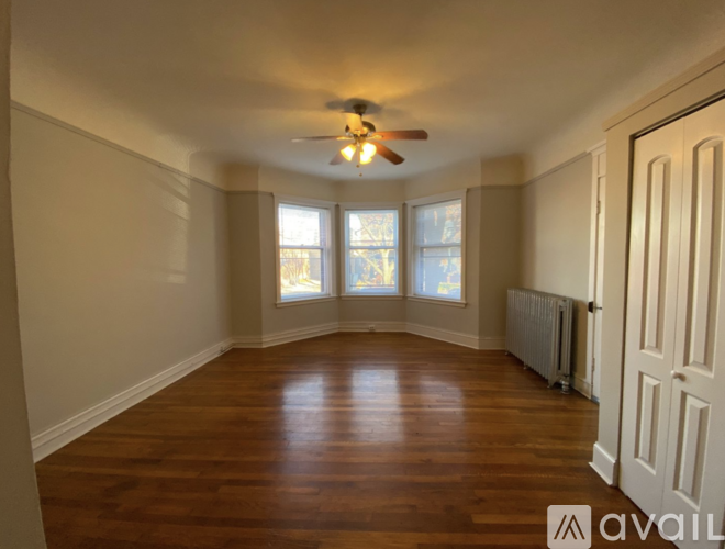A room with wooden floors and a ceiling fan.
