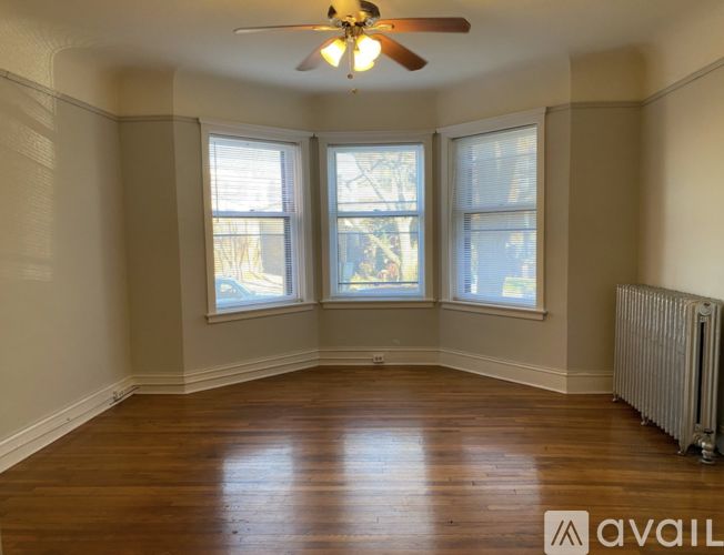 A room with wooden floors and a ceiling fan.