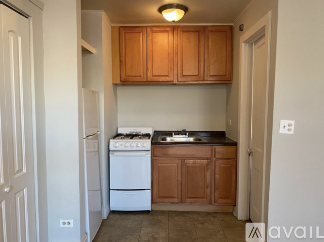 A kitchen with wooden cabinets and a white stove top oven.