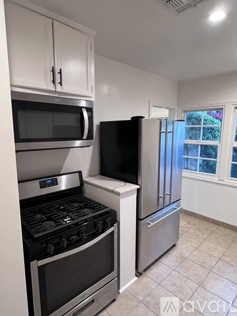 A kitchen with a stove, microwave, and refrigerator.